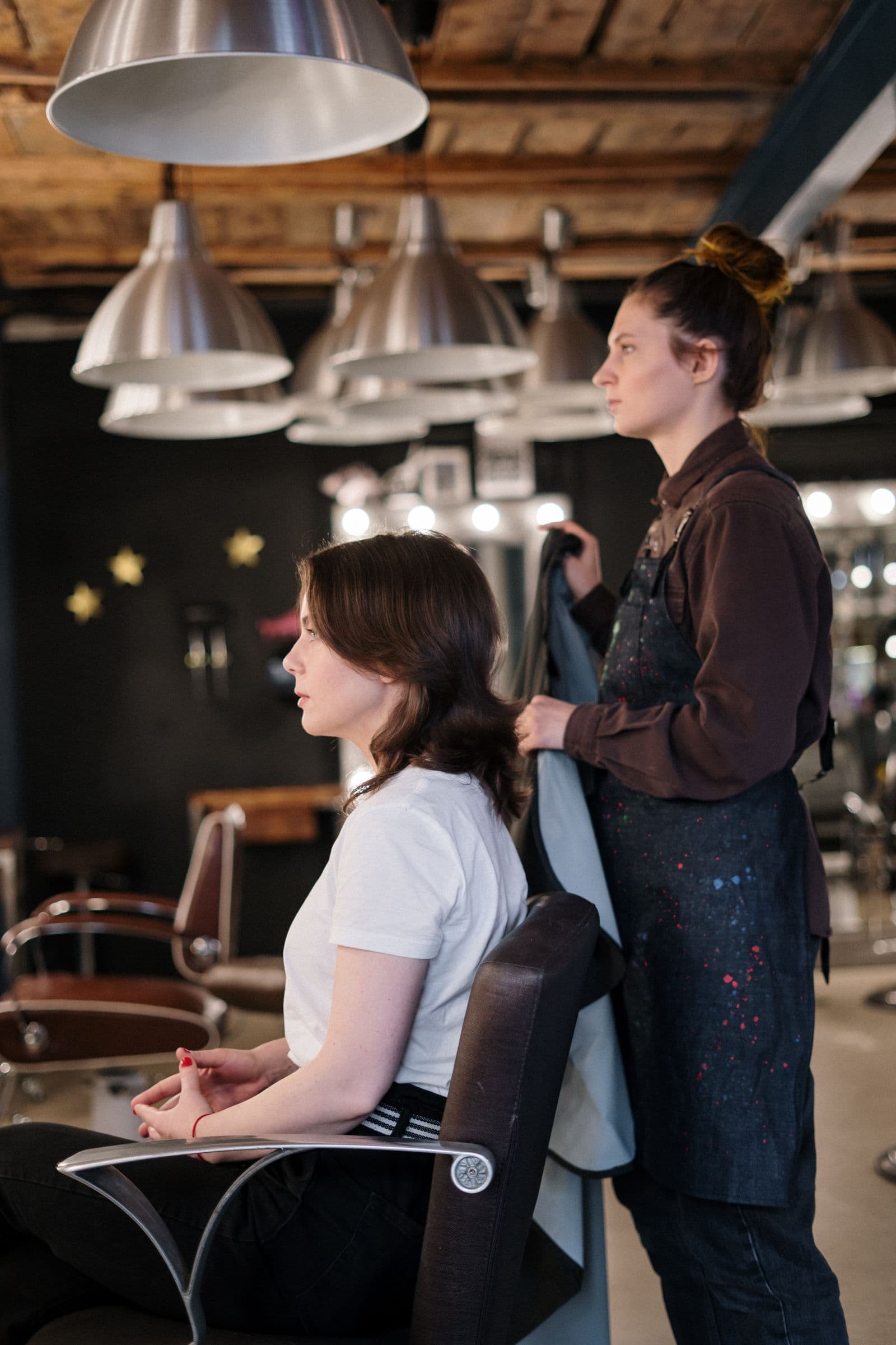 Stylist preparing a client in a contemporary salon.